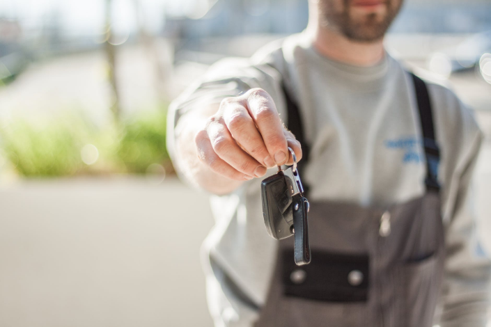 a person handing a car key